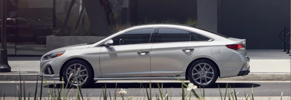 Gray 2019 Hyundai Sonata parked on a city street next to a planter.